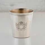 Silver cup with engraved emblem on a light gray background