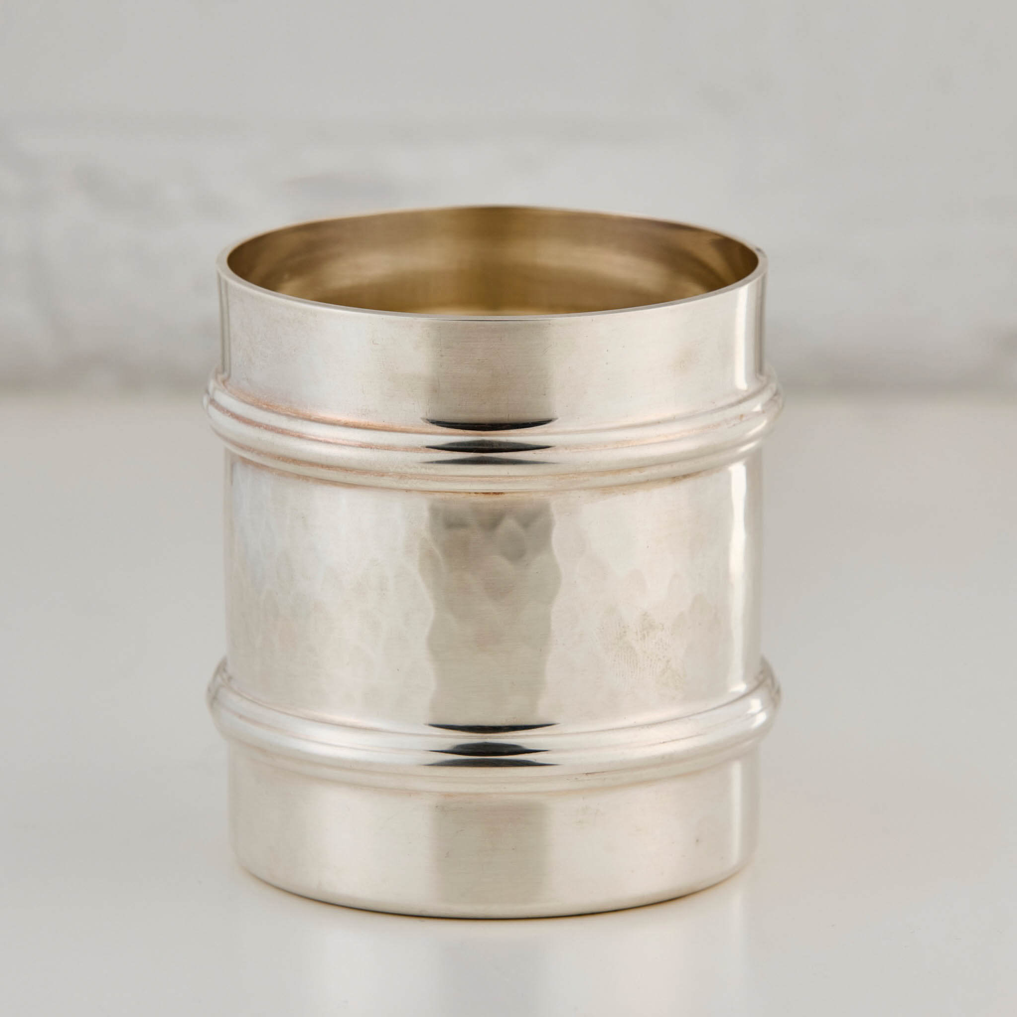 Silver cup on a light gray background