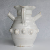 White ceramic pitcher with decorative elements on a gray background