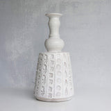 White ceramic vase with textured design on a gray background