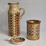 Set of ceramic Malarmey pitcher, dish, and jar with leaf patterns on a neutral background