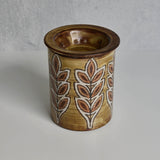 Ceramic Malarmey lidded jar with leaf patterns on a gray background