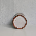 The bottom of a ceramic jar with 'Malarmey' signature on a gray background