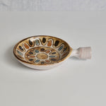 Ceramic dish with decorative patterns on a plain background